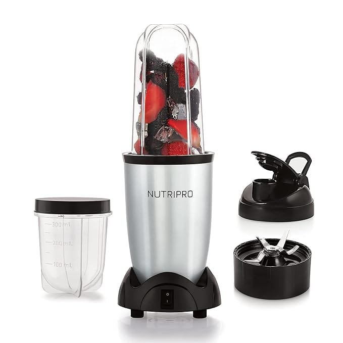 NutriPro Juicer Mixer Grinder - Smoothie Maker - 500 Watts with multiple accessories, including blending cups, a blade attachment, and a to-go lid, shown with fresh fruits inside.